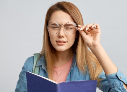Une femme avec des lunettes plisses les yeux pour réussir à voir correctement