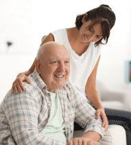 Happy elderly man with his daughter at home